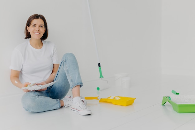 Il progettista sorridente della donna sceglie il migliore colore per l'appartamento