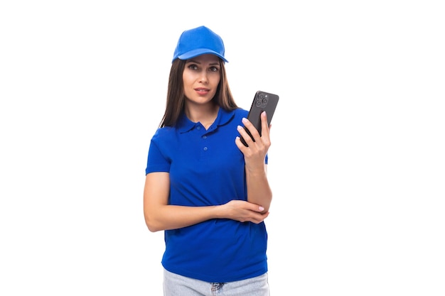 Il promotore di una giovane donna con una maglietta e un berretto blu utilizza uno smartphone