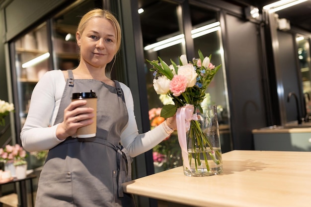 Il proprietario del negozio di fiori beve il caffè prima del lavoro