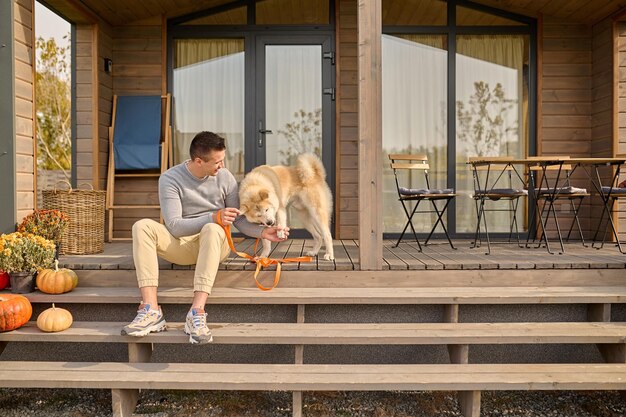 Il proprietario dell'animale domestico addestra il suo amico canino sulla veranda