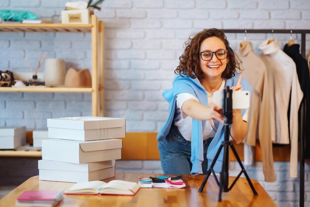 Il proprietario di una piccola impresa dropshipping del venditore dell'operaio del magazzino femminile che registra nuovi contenuti per il vlog