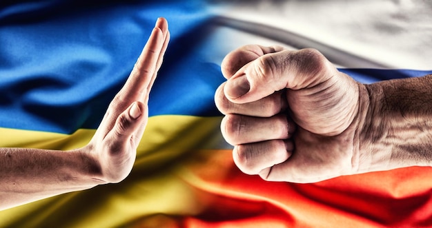Il pugno che esprime aggressività sulla bandiera russa mentre la mano mostra il gesto di arresto è sopra la bandiera ucraina