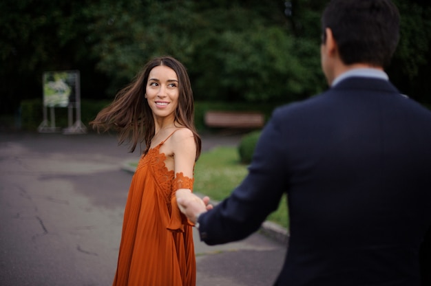 Il punto di vista posteriore dell'uomo è vestito che tiene la bella mano della donna