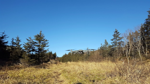 Il quadricottero sta volando nel cielo blu nelle zone montuose. Uav. Tecnologia moderna . All'aperto.