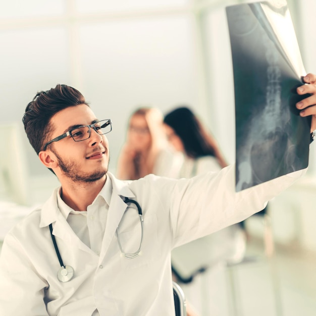 Il radiologo medico felice esamina i raggi x .foto con copia spazio