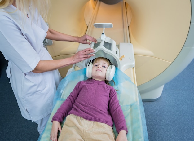 Il radiologo prepara la bambina per un esame del cervello MRI