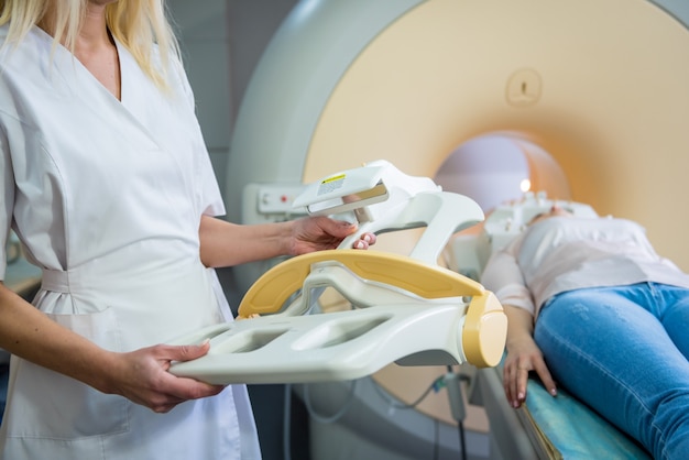 Il radiologo prepara la giovane donna per un esame del cervello MRI