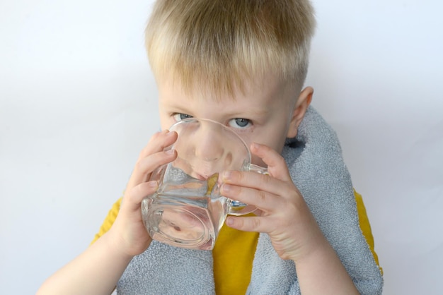 il ragazzino beve l'acqua da un bicchiere