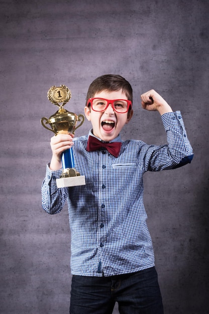 Il ragazzino celebra il suo trofeo d'oro