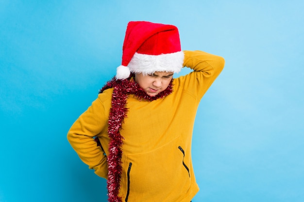 Il ragazzino che celebra il giorno di Natale che porta un cappello di Santa ha isolato il dolore di sofferenza del collo dovuto lo stile di vita sedentario.
