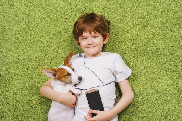 Il ragazzino con un cane ascolta musica.