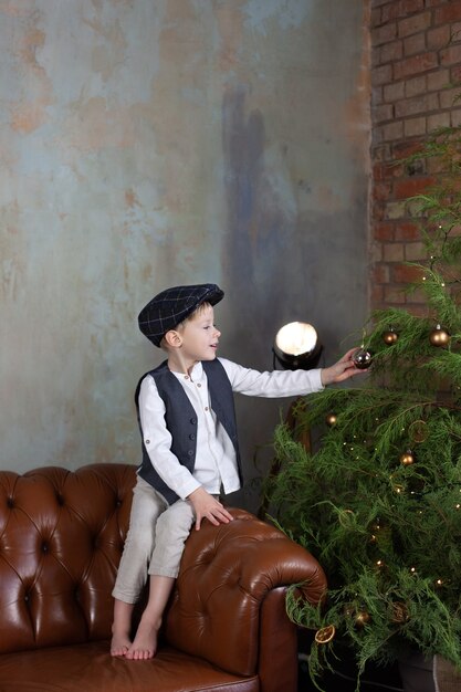 Il ragazzino decora l'albero di Natale per le vacanze