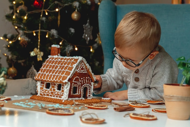 Il ragazzino decora la casa di marzapane di Natale