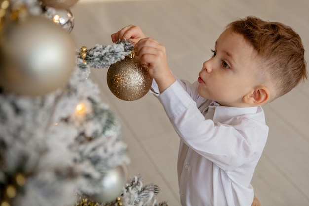 Il ragazzino decora un albero di Natale per Natale