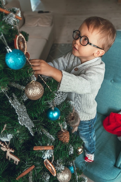 Il ragazzino decora un albero di Natale