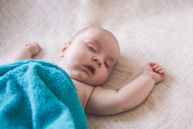 Il ragazzino dorme sotto una coperta sul letto