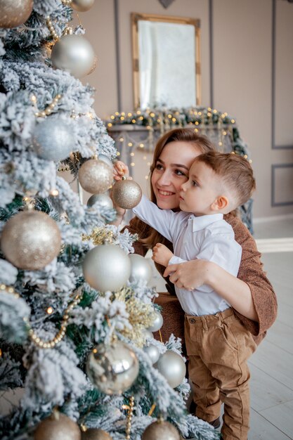 Il ragazzino e la madre decora un albero di Natale per Natale