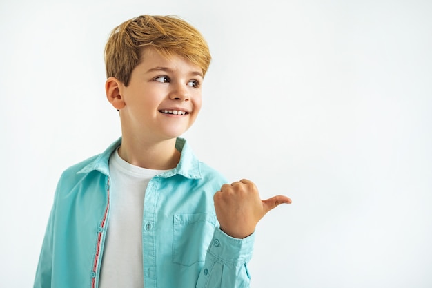 Il ragazzino felice che gesticola sullo sfondo bianco