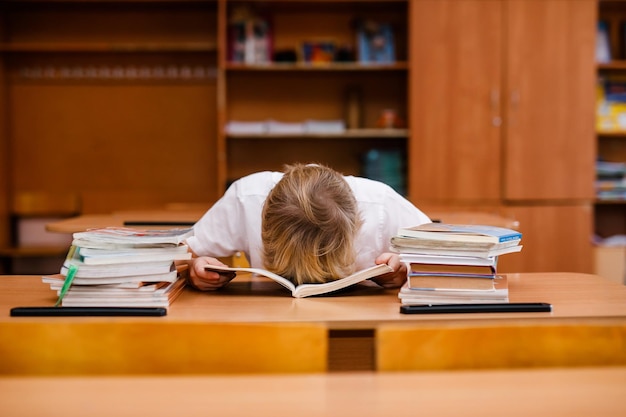 Il ragazzino felice ha un'idea Fare compiti scolastici con molti libri