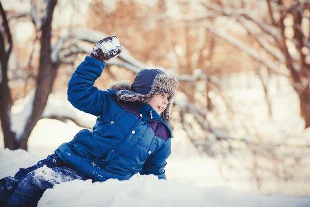 Il ragazzino gioca il parco dell&#39;inverno