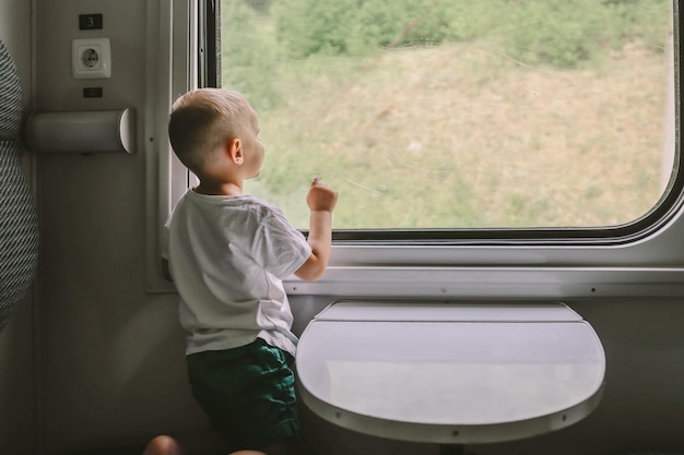 Il ragazzino guarda fuori dal finestrino del treno