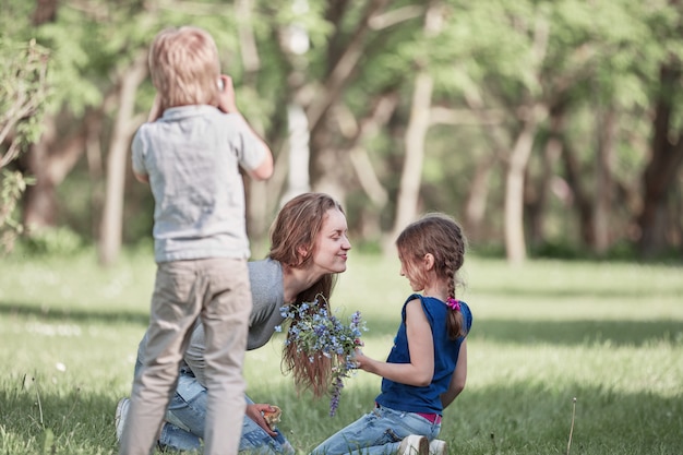 Il ragazzino scatta una foto di sua madre e sua sorella in una passeggiata nel parco.