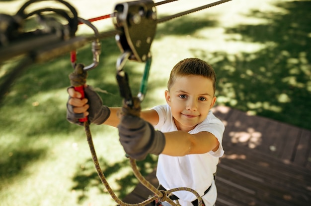 Il ragazzino si arrampica nel parco delle funi