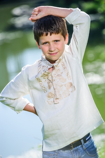 Il ragazzino sorridente felice si è vestito in vestito ucraino nazionale di stile.