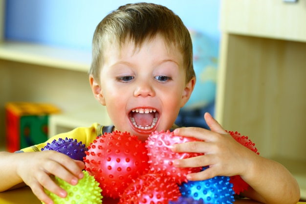 Il ragazzino sta giocando con le palle colorate