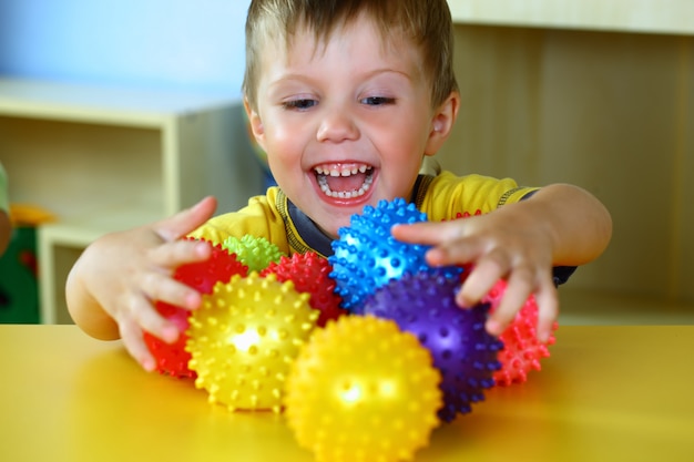 Il ragazzino sta giocando con le palle colorate