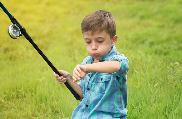 Il ragazzino sta pescando sul fiume