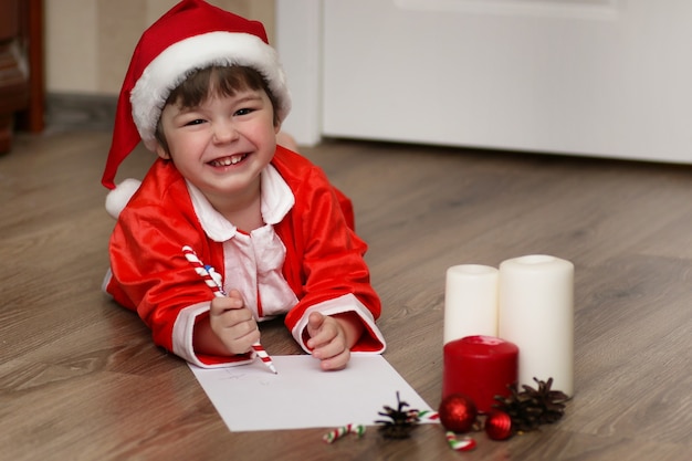 Il ragazzino sta scrivendo una lettera a Babbo Natale