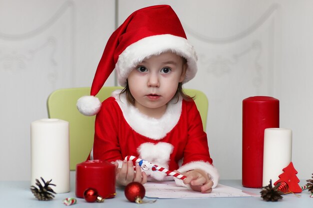 Il ragazzino sta scrivendo una lettera a Babbo Natale