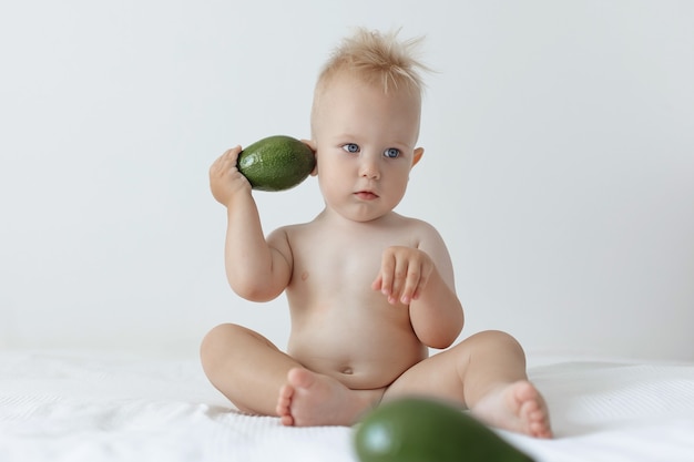 Il ragazzino tiene in mano l'avocado e sorride