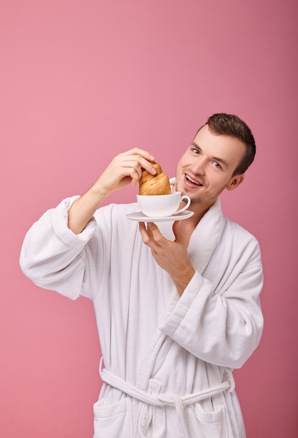 Il ragazzo allegro non può resistere per non mangiare il cornetto