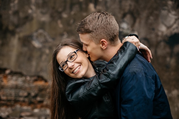 Il ragazzo amorevole sussurra all'orecchio della ragazza allegra all'aperto