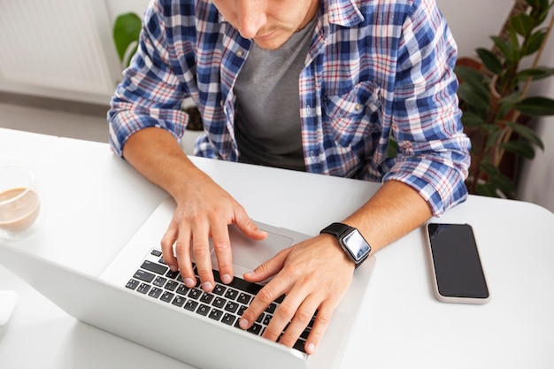 Il ragazzo che lavora con il laptop online da casa.