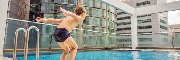 Il ragazzo che salta in piscina tra i grattacieli e la grande città si rilassa nella grande città da cui riposa