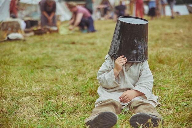 Il ragazzo che scherza si mette un secchio in testa al festival vichingo