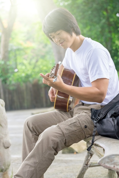 Il ragazzo che suona la chitarra, all&#39;aperto, pantaloni cargo