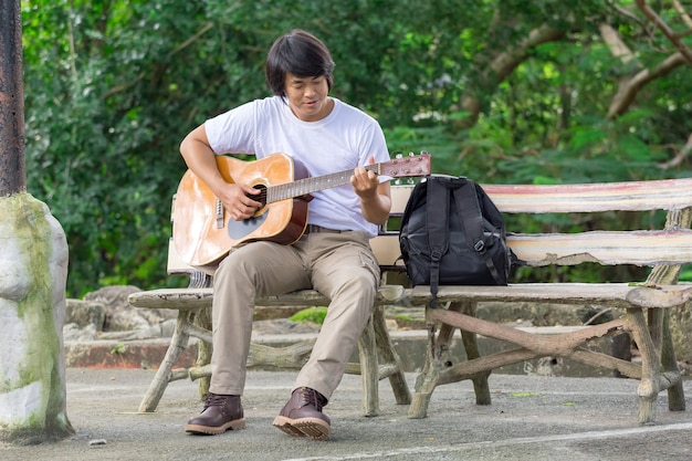 Il ragazzo che suona la chitarra, all&#39;aperto, pantaloni cargo