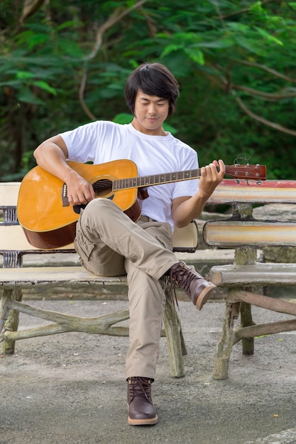 Il ragazzo che suona la chitarra, all&#39;aperto, pantaloni cargo