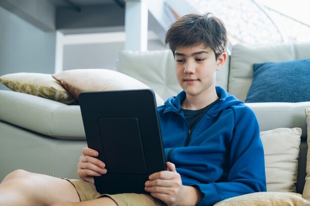 Il ragazzo che usa il tablet per comunicare online a casa