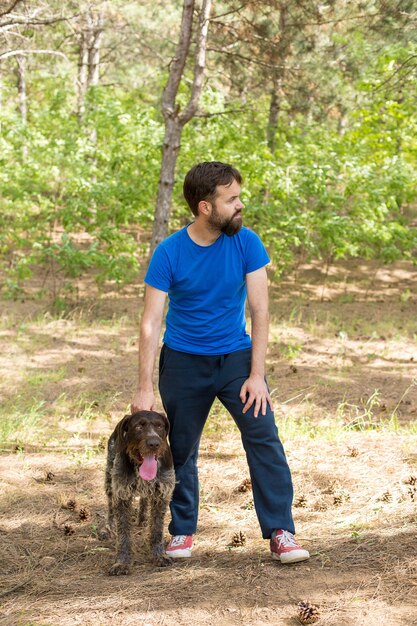 Il ragazzo con il cane nel parco cane da guardia di caccia tedesco drahthaar