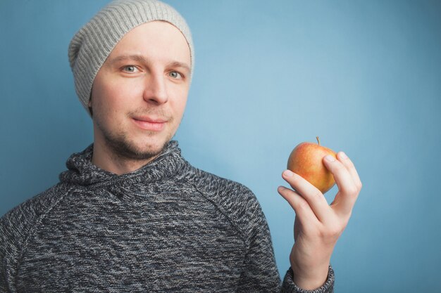 Il ragazzo con il cappello in mano una mela.