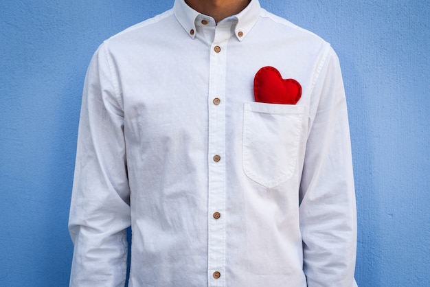 Il ragazzo con la camicia bianca con un biglietto di S. Valentino rosso in tasca
