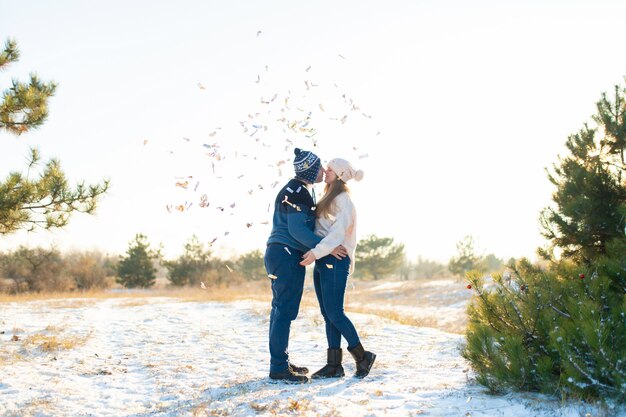 Il ragazzo con la ragazza bacia in inverno nei boschi. Romantica atmosfera invernale