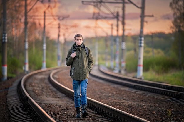 il ragazzo con lo zaino viaggia, percorre i binari