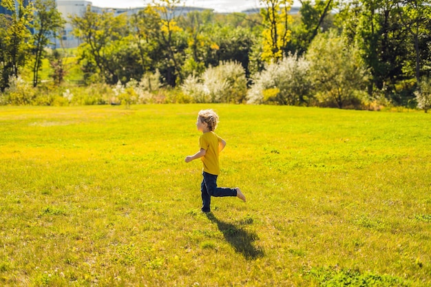 Il ragazzo corre nel parco sull'erba.