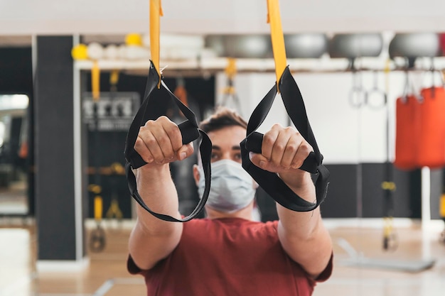 Il ragazzo di forma fisica tira le pulegge in palestra